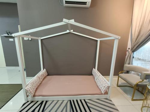 a bed frame in a room with a chair at Alchemy Guesthouse D'summit Residence with Netflix in Johor Bahru