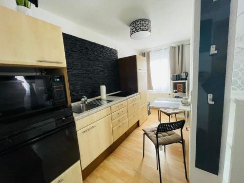 a kitchen with a sink and a black appliance at Barbarosa Rüsselsheim Königstädten 1 in Königstädten