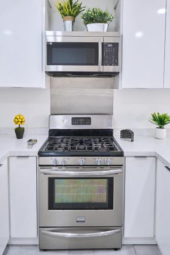 a kitchen with a stainless steel stove and a microwave at Marloma departamento #2 in Ensenada