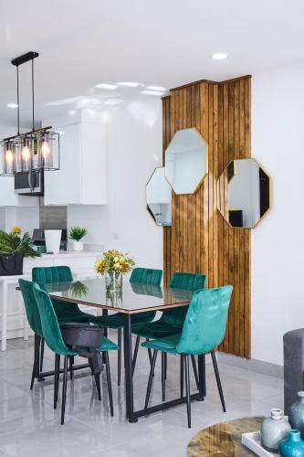 a dining room with a table and green chairs at Marloma departamento #2 in Ensenada