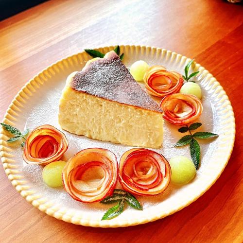 a white plate with a piece of cake and roses at 如沐咖啡旅宿 in Xingjian