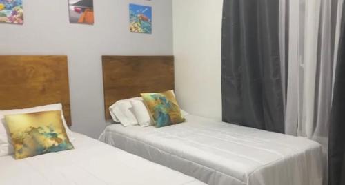 a bedroom with two beds with white sheets at Magic Beach para 6 personas frente al mar in Tela