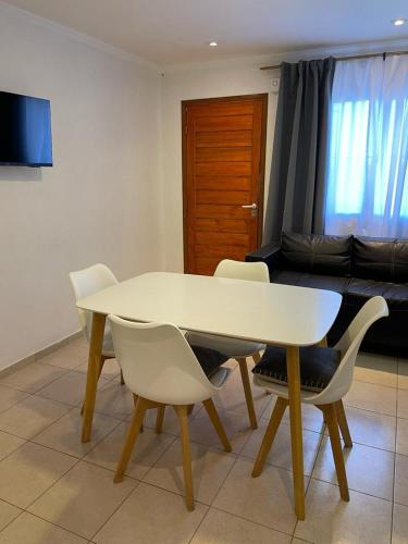 - une table et des chaises blanches dans le salon dans l'établissement departamento cerca centro viejo (no playa), à Necochea