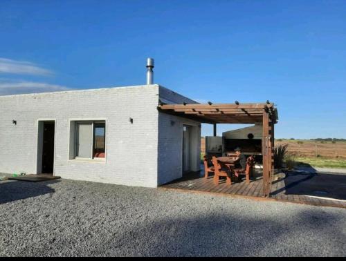 Casa con terraza de madera con mesa en Casa de Campo acogedora, en Trinidad