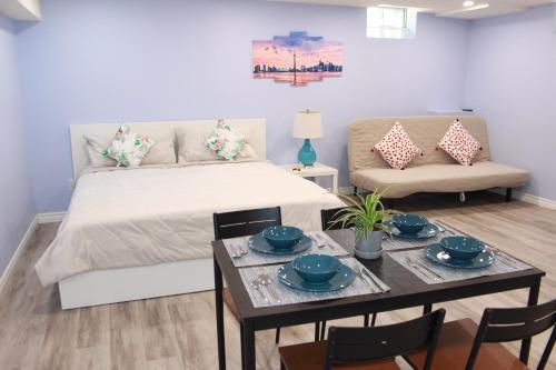 a bedroom with a bed and a table and a couch at Home Stay near the Airport in Mississauga