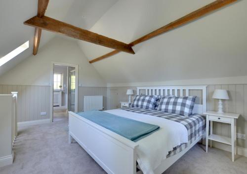 um quarto com uma grande cama branca num sótão em Middle Barn em Leigh