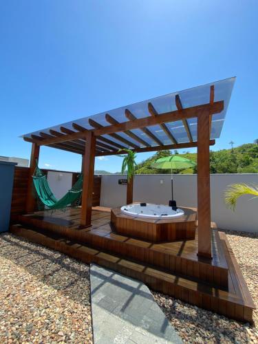 una terraza con bañera de hidromasaje y pérgola en Recanto da Natureza & SPA, en Penha