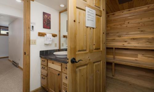 baño con lavabo y pared de madera en MVC Cardinal Sanctuary, en Big Sky