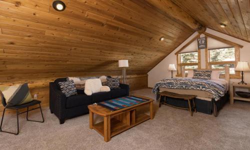 1 dormitorio con 1 cama y 1 sofá en una cabaña en MVC Cardinal Sanctuary, en Big Sky