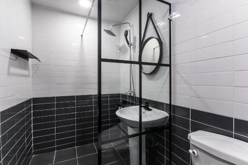 a black and white bathroom with a sink and a mirror at Hotel The City in Gwangju