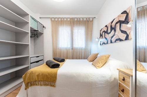 a bedroom with a white bed and a television at Plaza De la Iglesia in Rincón de la Victoria