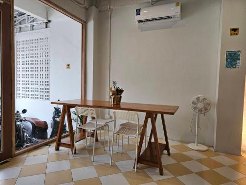 a wooden table and chairs in a room with a window at Hao Norn Hostel in Thong Sala