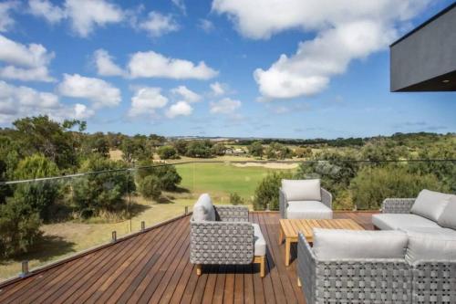 a deck with couches and a view of a golf course at The Moonah Residence in Fingal