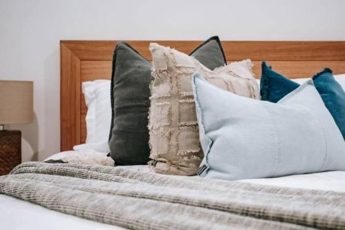 a pile of pillows sitting on a bed at The Moonah Residence in Fingal
