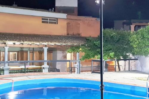 a blue swimming pool in front of a building at Casa en Villa Carlos Paz in Villa Carlos Paz