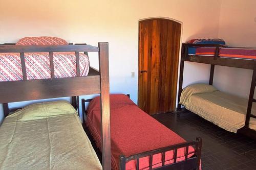 a room with three bunk beds in a room at Casa en Villa Carlos Paz in Villa Carlos Paz