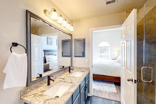 a bathroom with two sinks and a large mirror at Arbor Glen Zen in Conroe