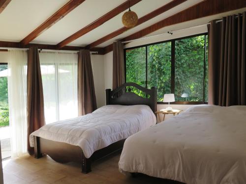 1 Schlafzimmer mit 2 Betten und einem großen Fenster in der Unterkunft Casa El Rancho 1 in Estero