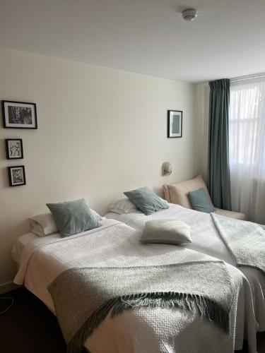 a bedroom with a large bed with a blanket on it at Le Téméraire Hôtel in Charolles