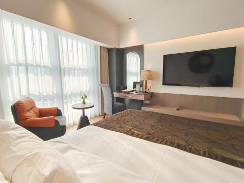 a hotel room with a bed and a flat screen tv at Merry Hotel Shanghai (Former Rendezvous Merry Hotel Shanghai) in Shanghai