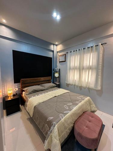 a bedroom with a large bed and a window at Grey Oasis Staycation 1 Bedroom in Manila