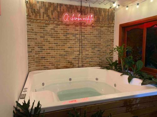 a large bath tub in a room with a brick wall at Casa EstadioMed in Medellín