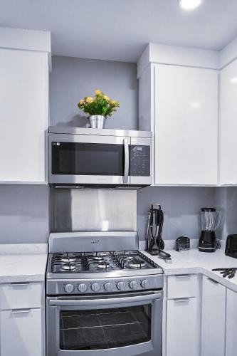 a kitchen with a stove and a microwave at Departamento Marloma #1 in Ensenada