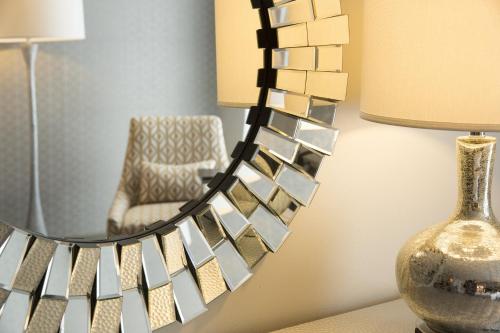 a mirror on a wall with a chair and a lamp at Crowne Plaza Chicago SW - Burr Ridge, an IHG Hotel in Burr Ridge