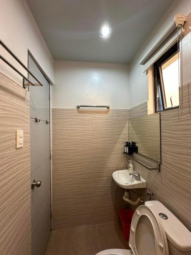 a bathroom with a toilet and a sink at Grey Oasis Staycation 1 Bedroom in Manila