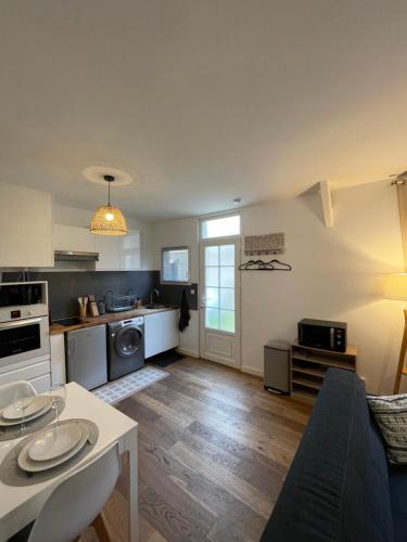 une cuisine et un salon avec un canapé et une table dans l'établissement Sleepin Orléans - Parking - Netflix, à Orléans