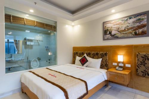 a bedroom with a large bed and a glass shower at Sapa Snow Hotel in Sa Pa