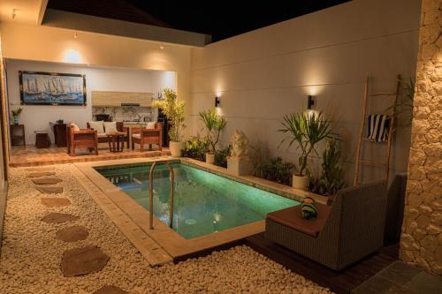 a swimming pool in the middle of a house at Shanta Villa in Sanur