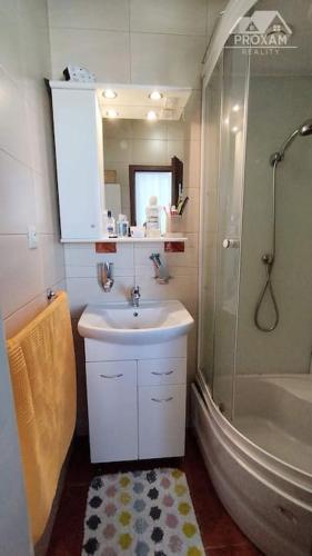 W łazience znajduje się umywalka, prysznic i wanna. w obiekcie Celý byt pre vás w Łuczeńcu