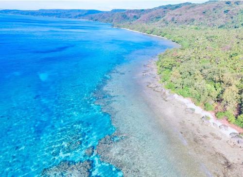 een luchtzicht op de kustlijn van een strand bij M Resort & Spa in Port Vila