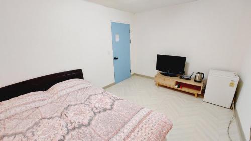 コヤンにあるMokhwajang Motelのベッドルーム(ベッド1台、テレビ付)