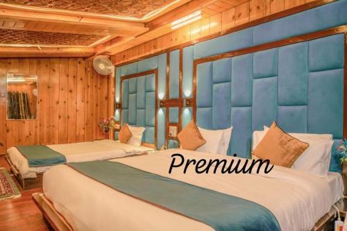 two beds in a room with a blue wall at hotel khalil in Gulmarg