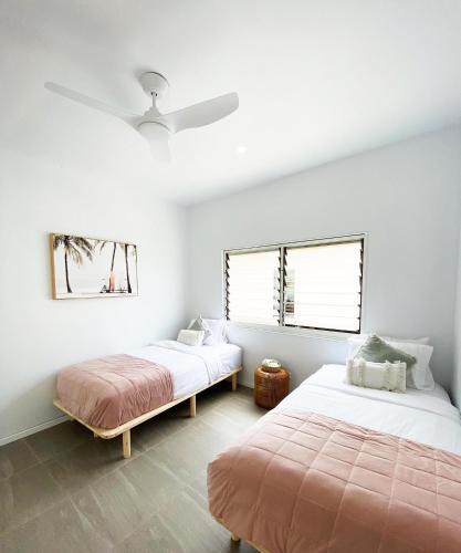 a bedroom with two beds and a ceiling fan at M Resort & Spa in Port Vila
