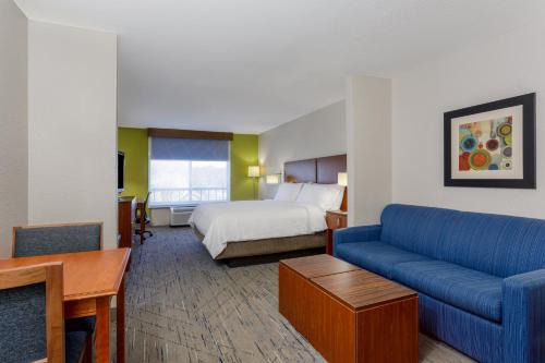 a hotel room with a bed and a couch at Holiday Inn Express & Suites Jacksonville South - I-295 by IHG in Jacksonville