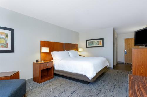 a hotel room with a bed and a flat screen tv at Holiday Inn Express & Suites Jacksonville South - I-295 by IHG in Jacksonville