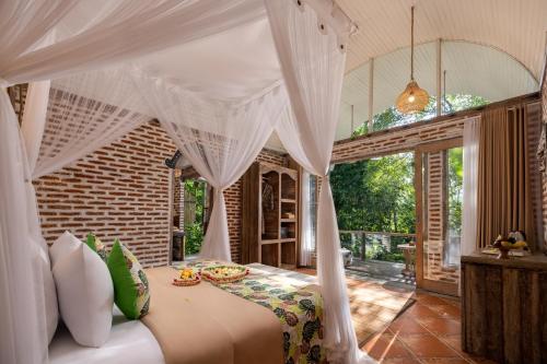 a bedroom with a bed with a canopy at Sacred Canyon Ubud by GenuineHost in Payangan