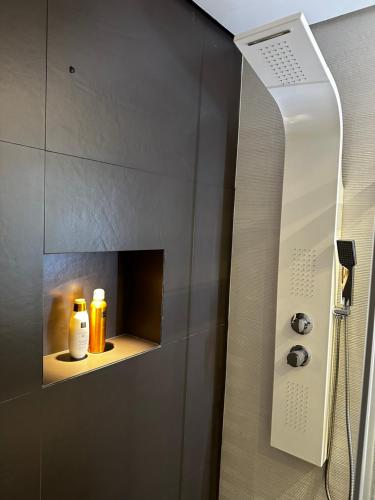 uma casa de banho com um chuveiro e 2 garrafas numa prateleira em ADEJE PARADISE RESORT em Adeje
