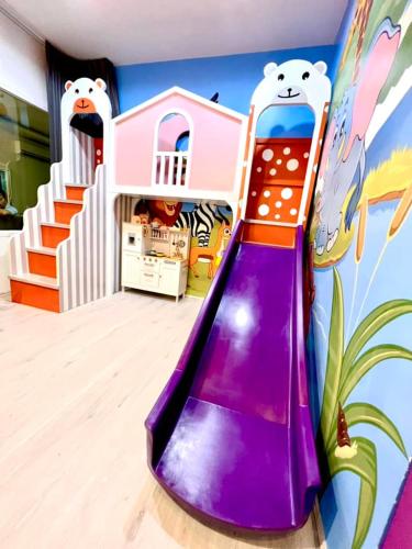 a purple slide in a room with a mural at Cocomelon Poolvilla1 in Hua Hin