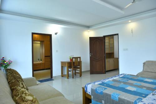 - un salon avec un lit et une table dans l'établissement Aquavista lake view apartment, à Trivandrum
