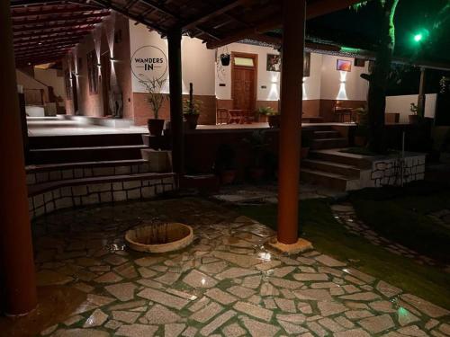 a building with a stone patio with a bowl at Wanders In Coffee Stays in Madikeri