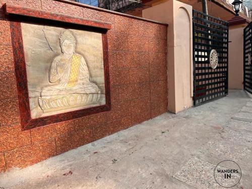 a painting of a buddha on the side of a wall at Wanders In Coffee Stays in Madikeri