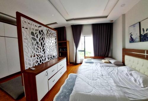 a bedroom with two beds and a large window at Homestay Thule in Ho Chi Minh City