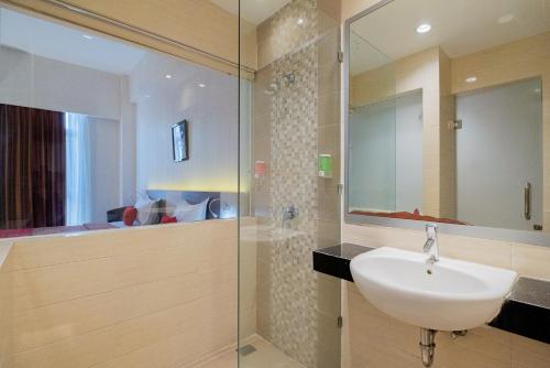 y baño con lavabo y ducha. en RedDoorz Premium @ Jalan Veteran Bojonegoro en Bojonegoro