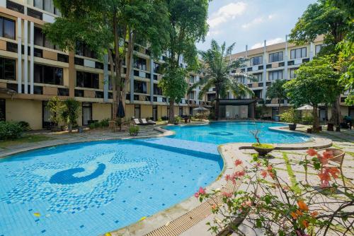 a large swimming pool in front of a building at RedDoorz Premium @ Jalan Veteran Bojonegoro in Bojonegoro