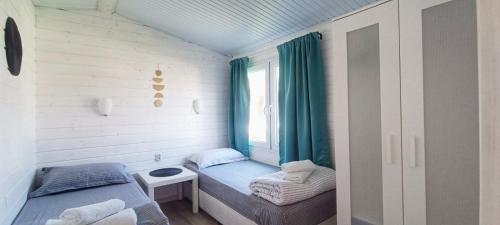 Cette petite chambre comprend un lit et une fenêtre. dans l'établissement Къщички Морски Светулки, à Sinemorets