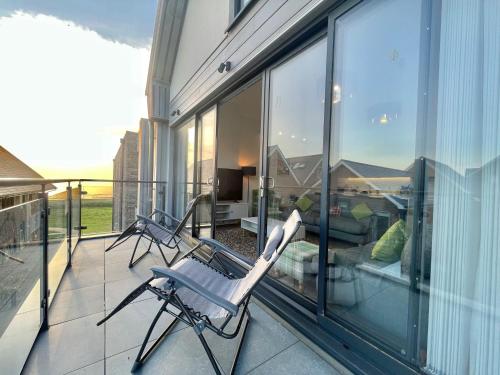 a balcony with two chairs sitting on top of a house at 47 The Rest in Porthcawl